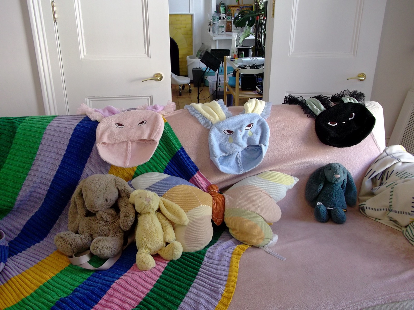 HOHOMIE bunny caps and plush props arranged on a pastel couch